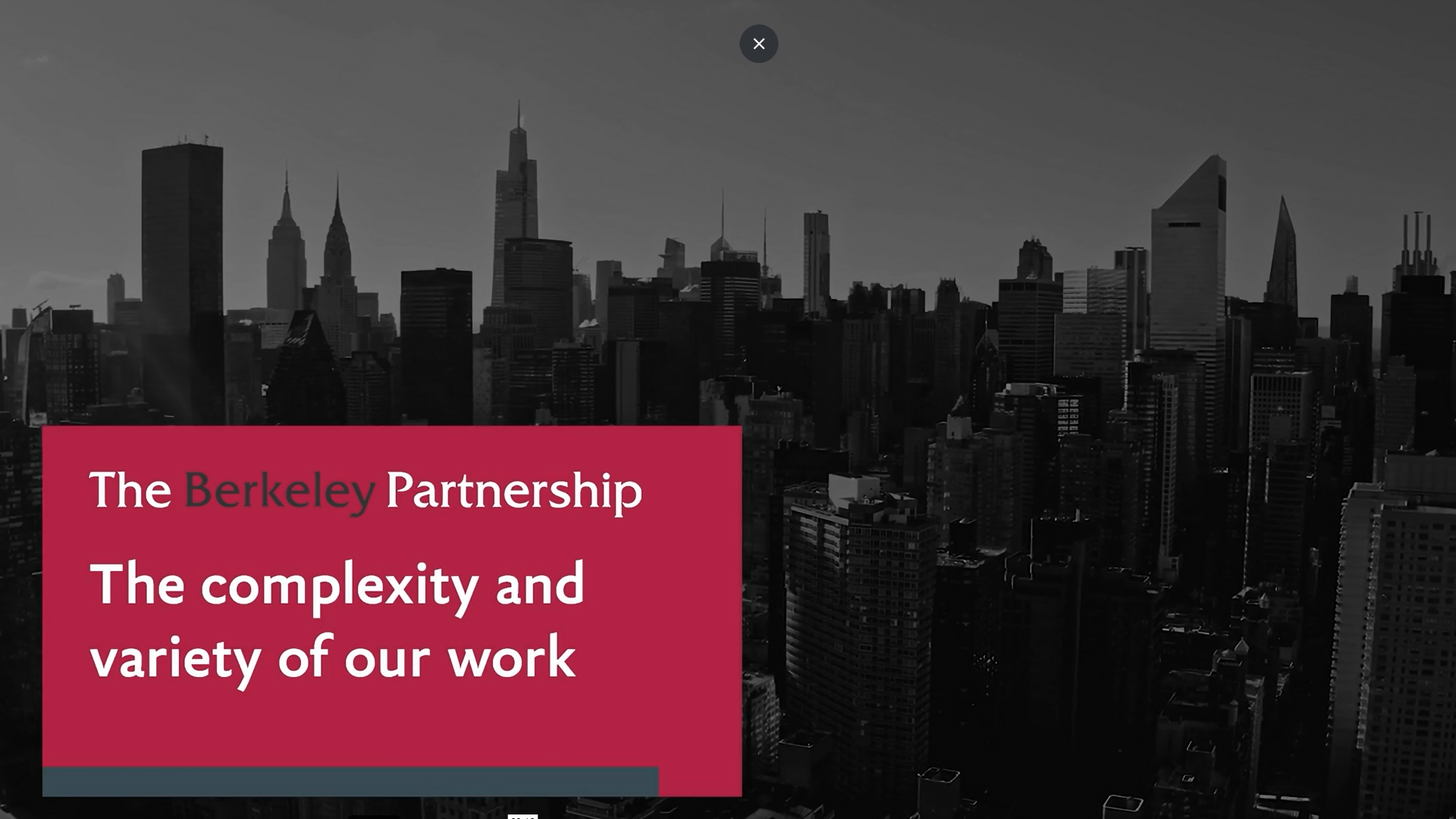 An on-screen banner says, "The complexity and variety of our work." A grayscale image of a New York City skyline is in the background.
